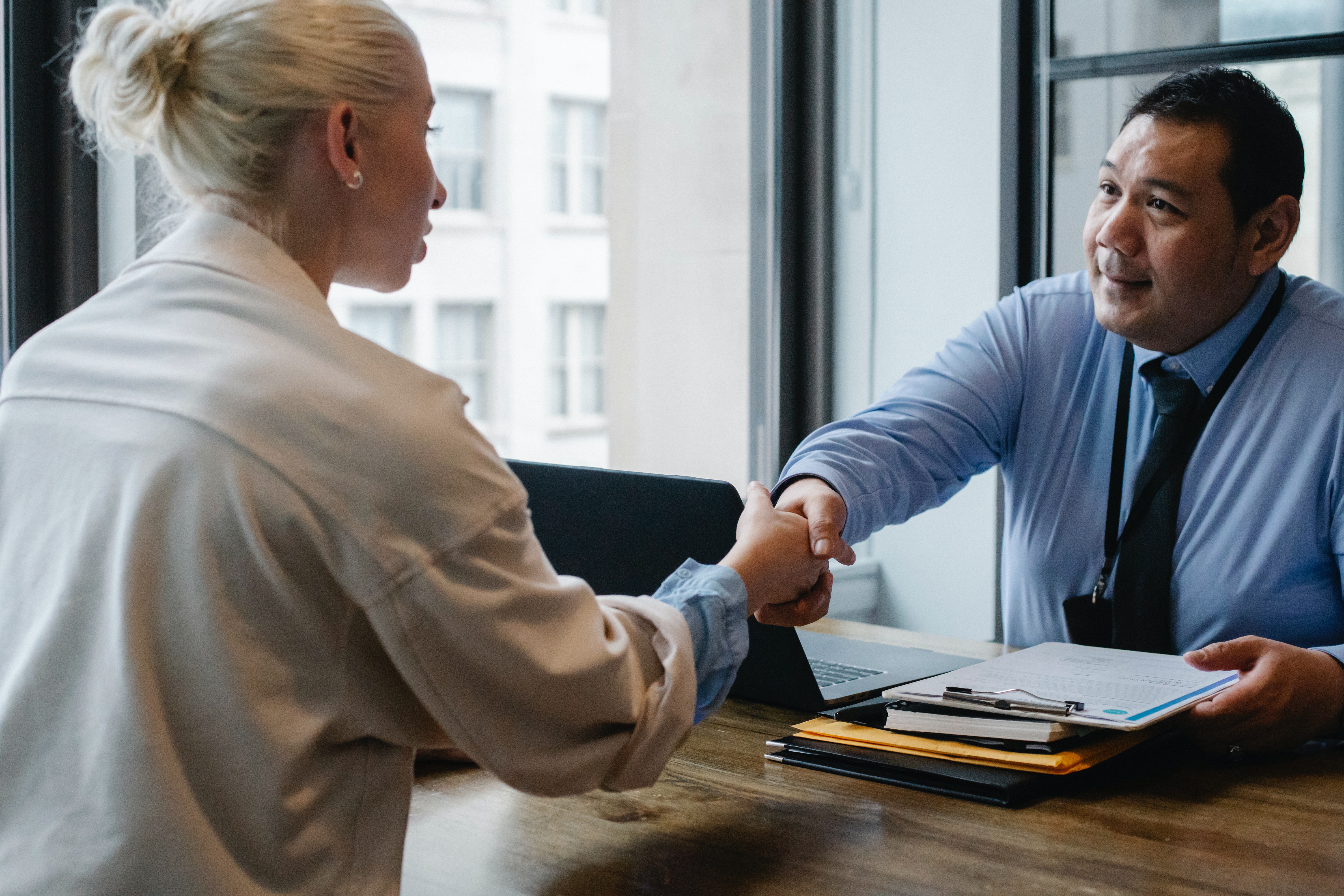 An independent insurance agent  and policyholder shaking hands.
