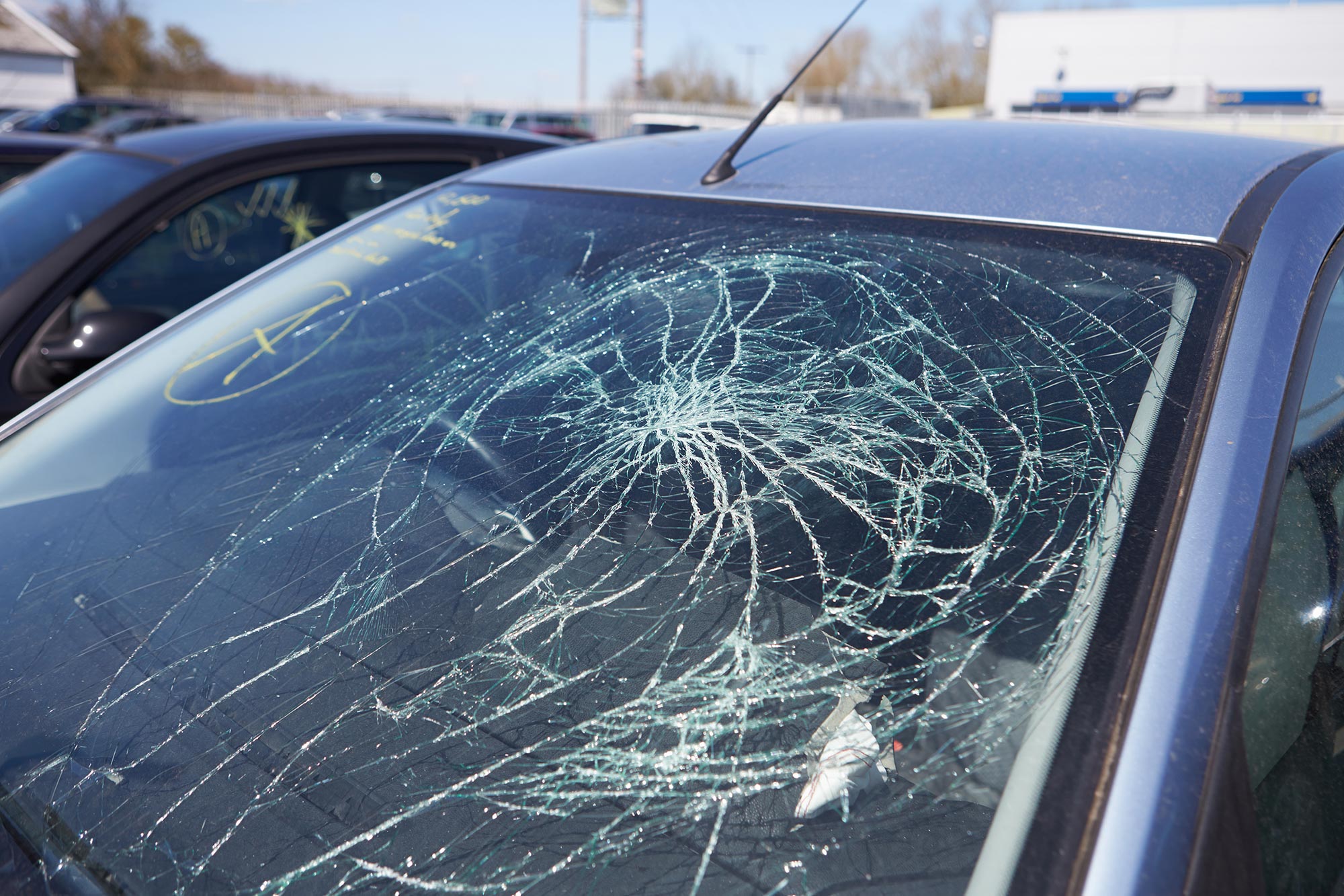 Close up shot of a car with a severely cracked wind shield.