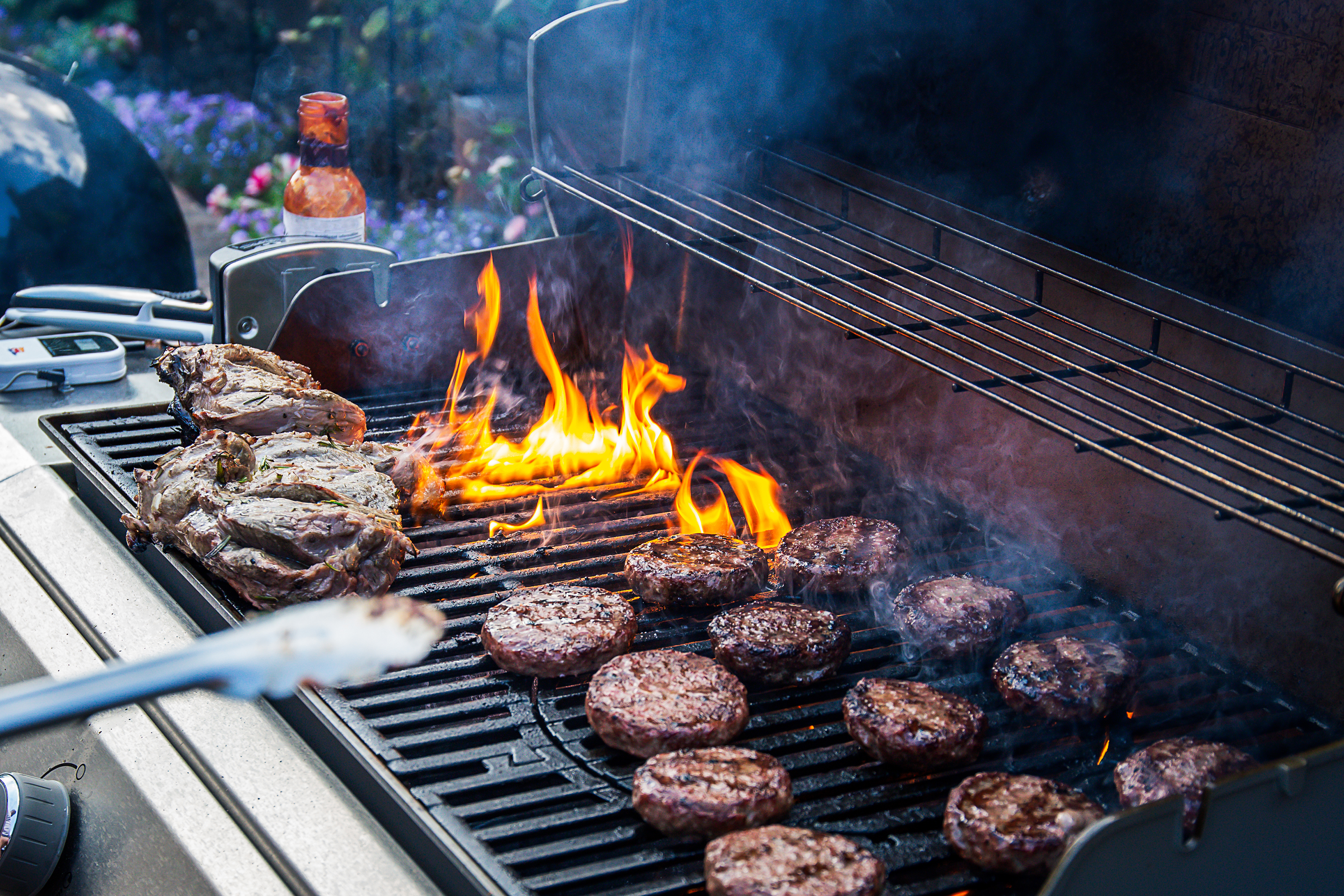 Meat being cooked on a gas grill.