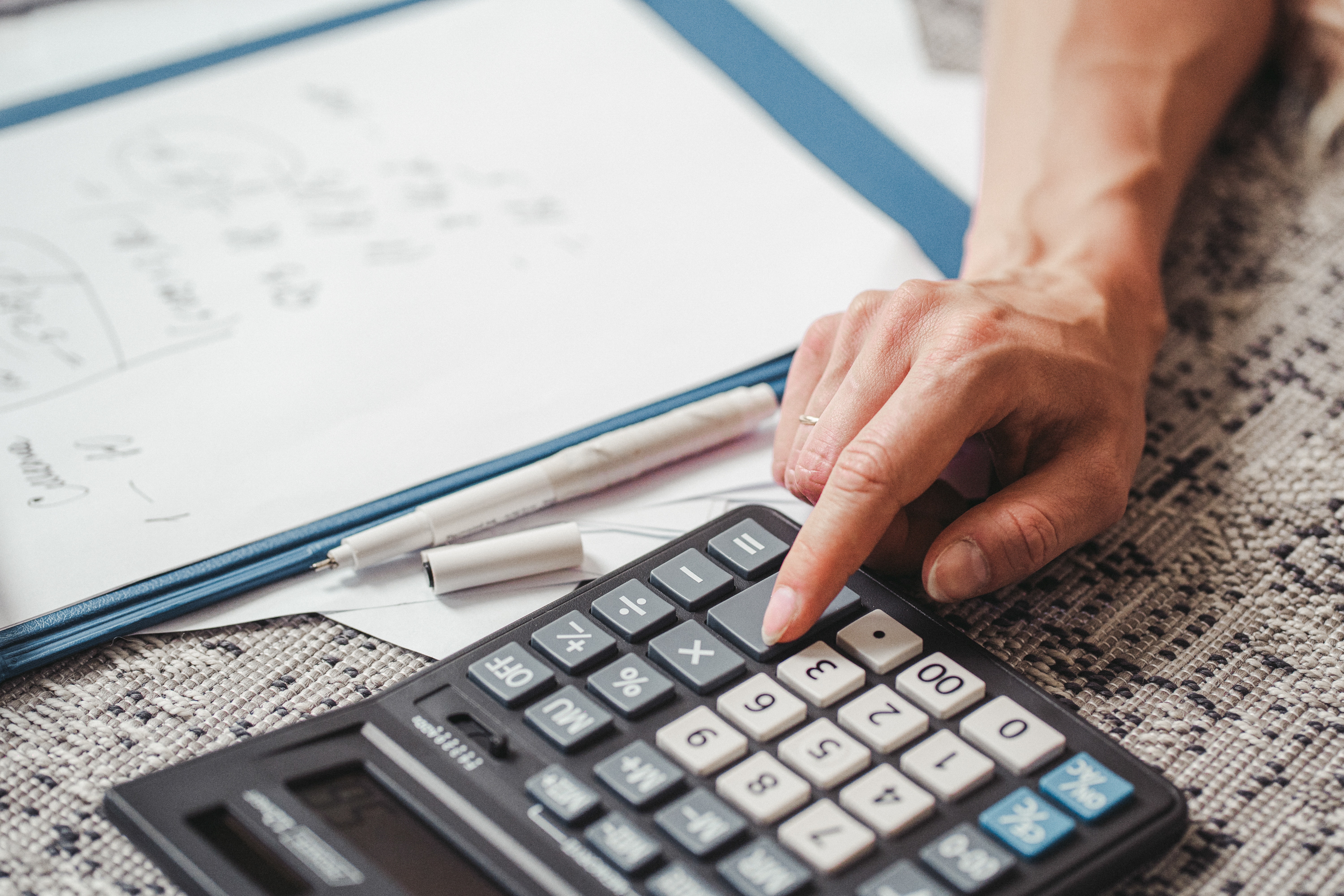 Close up of person using calculator.