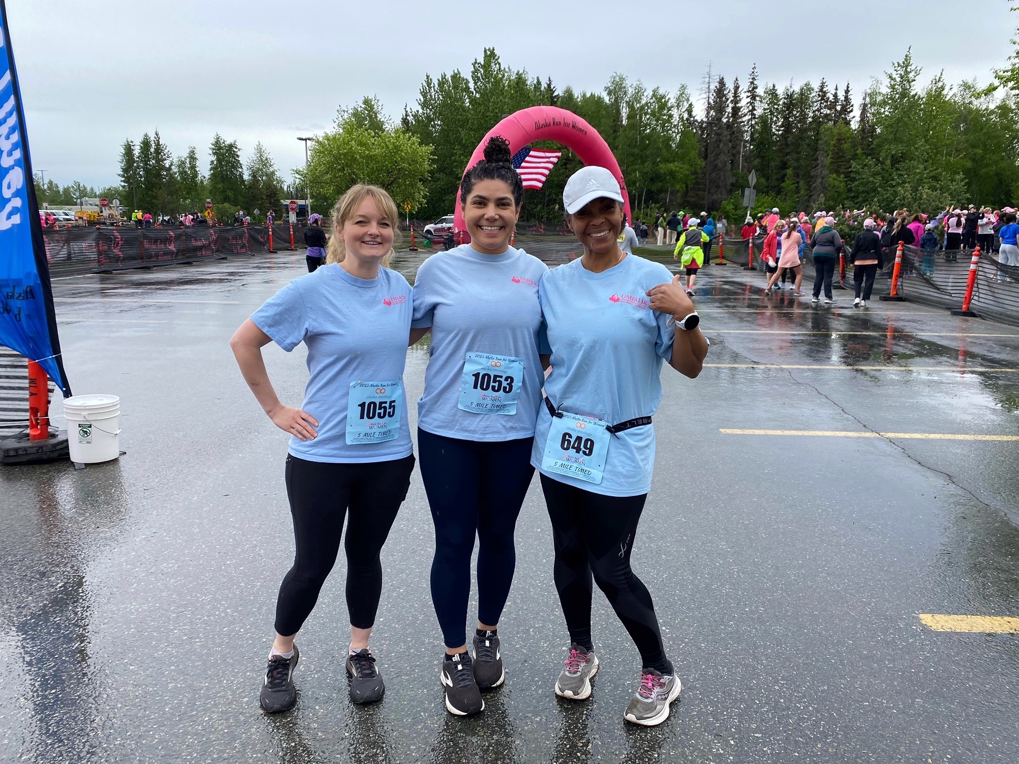 Three Umialik employees posing together in race gear at the Alaska Run for Women.